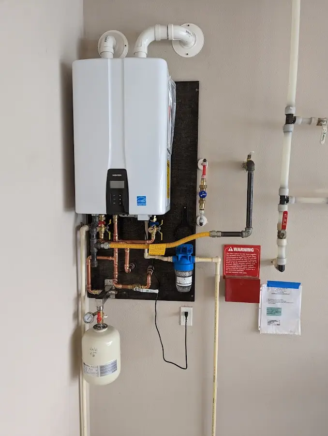 Professional plumber installing copper piping in a Staples home